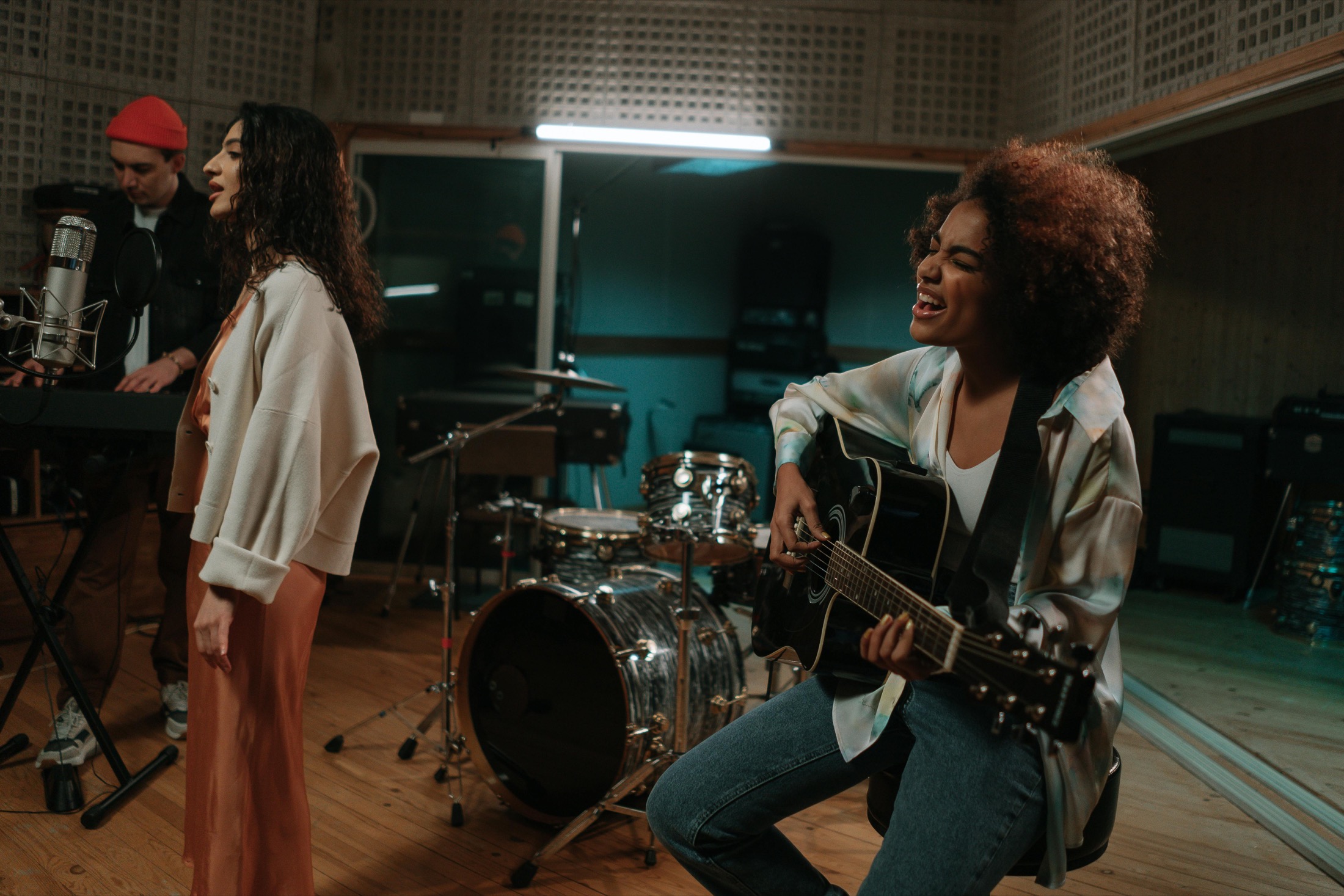 Women musicians recording vocals and guitar Women musicians recording vocals and guitar in a studio